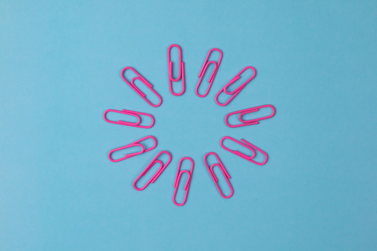una scrittura è efficace se è chiaro il valore di ciò che sta raccontando - per rappresentare il concetto, nell'immagine si vedono diverse graffette rosa posizionate in cerchio su sfondo azzurro